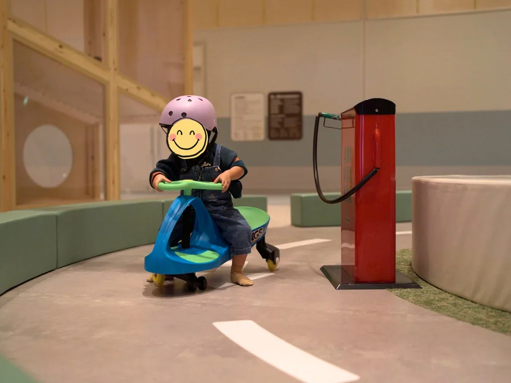 グランドメルキュール八ヶ岳のキッズスペースで、ヘルメットをかぶった子どもが乗り物で遊ぶ様子